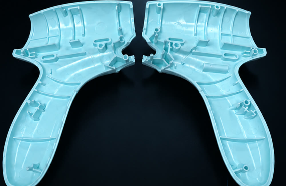 Interior view of two injection molded ultrasonic surgical handle shell halves with ribs and mounting bosses